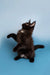 Black Maine Coon kitten standing on hind legs with paws raised, adorable and playful