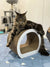 Long-haired tabby Maine Coon kitten lounging on a curved scratching post