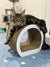 Long-haired tabby Maine Coon kitten relaxing on a stylish curved scratching post