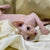 Sphynx Kitten named Stephen with big eyes lounging on white fabric