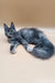 Gray long-haired Maine Coon kitten lounging cutely on a cozy surface